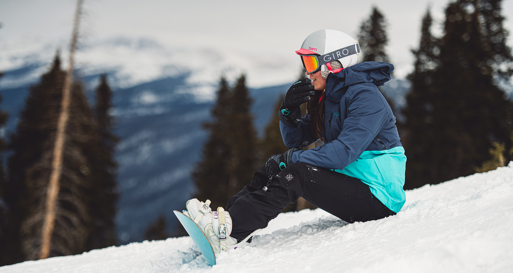 Woman straps into snowboard